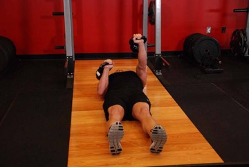 Press en suelo alterno con kettlebell: posición final